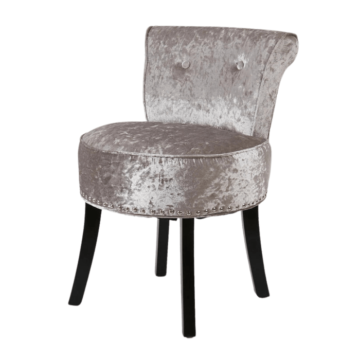 Round velvet upholstered vanity stool chair in silver-grey color with button tufting and rivet detailing
