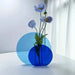 Two transparent round acrylic vases, one 22 cm tall and the other 15 cm tall
