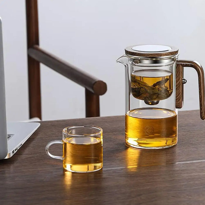 Gray glass teapot with ergonomic wooden handle and intelligent tea separation system for a seamless brewing experience
