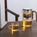 Gray glass teapot with ergonomic wooden handle and intelligent tea separation system for a seamless brewing experience
