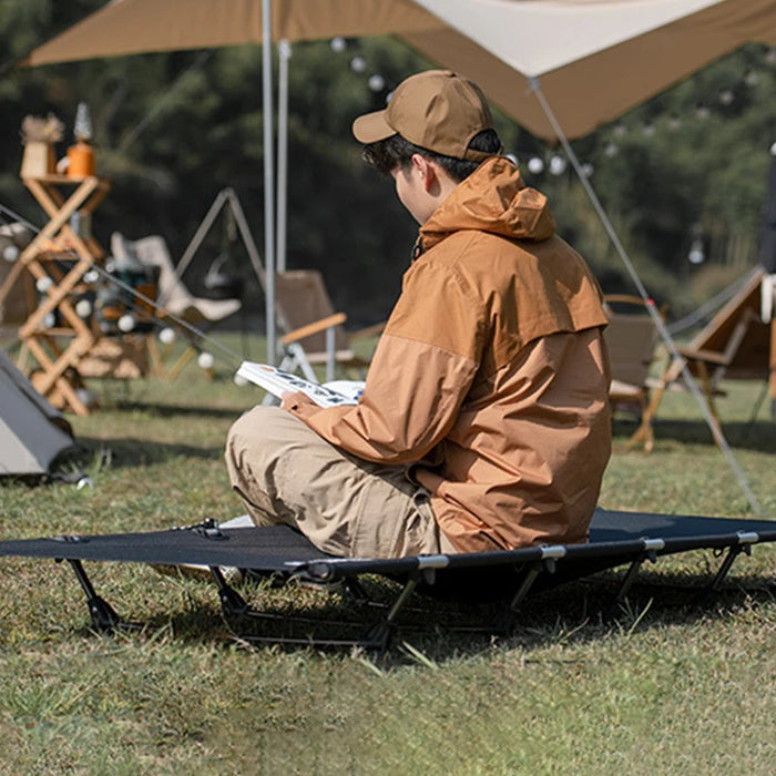 Portable black camp bed with folding structure and dedicated storage bag